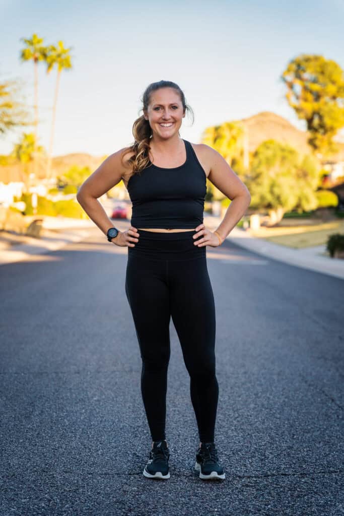 Woman in fitness attire standing on street