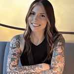 Woman with tattoos smiling at table